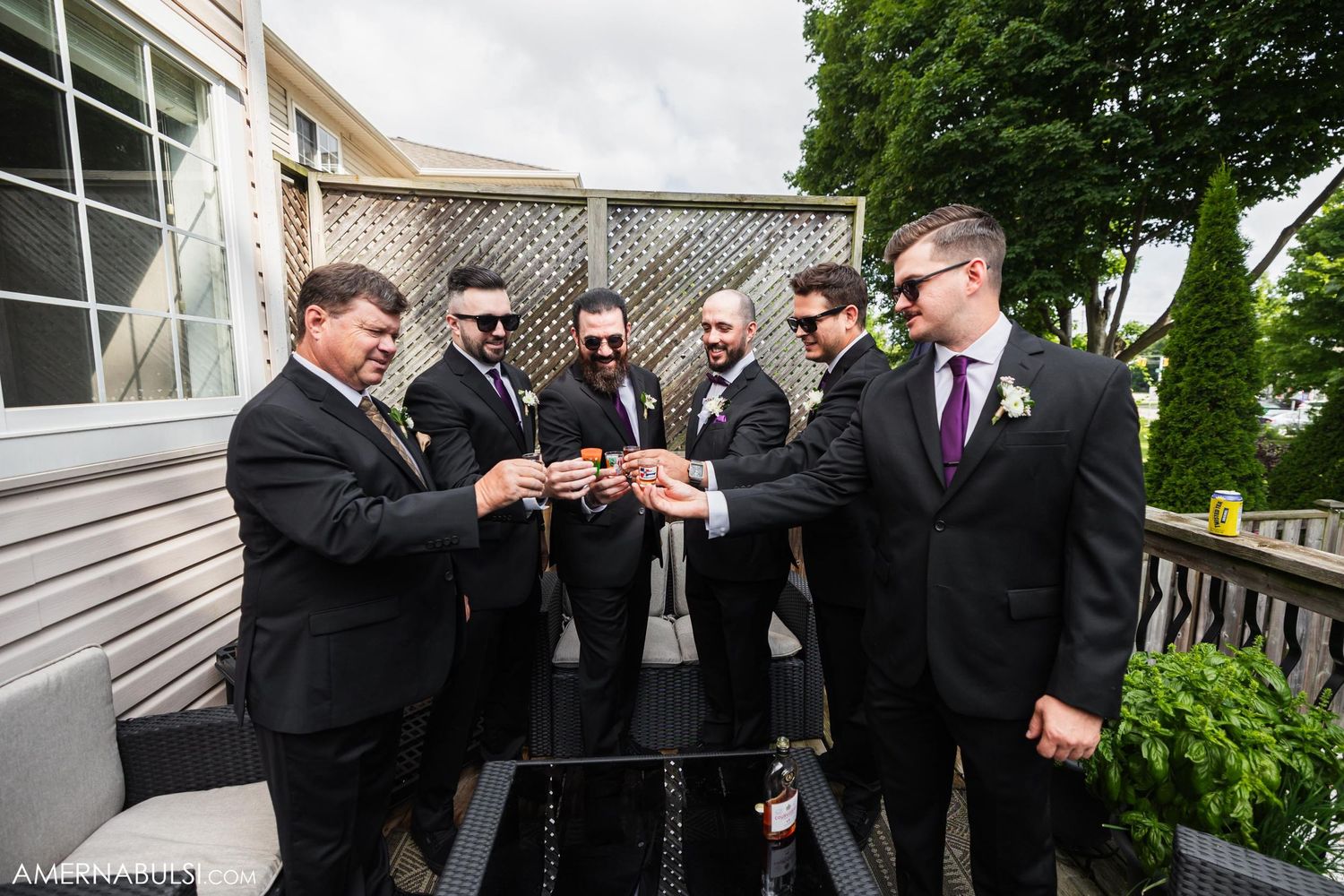 Group in formal attire toasting drinks on outdoor deck.