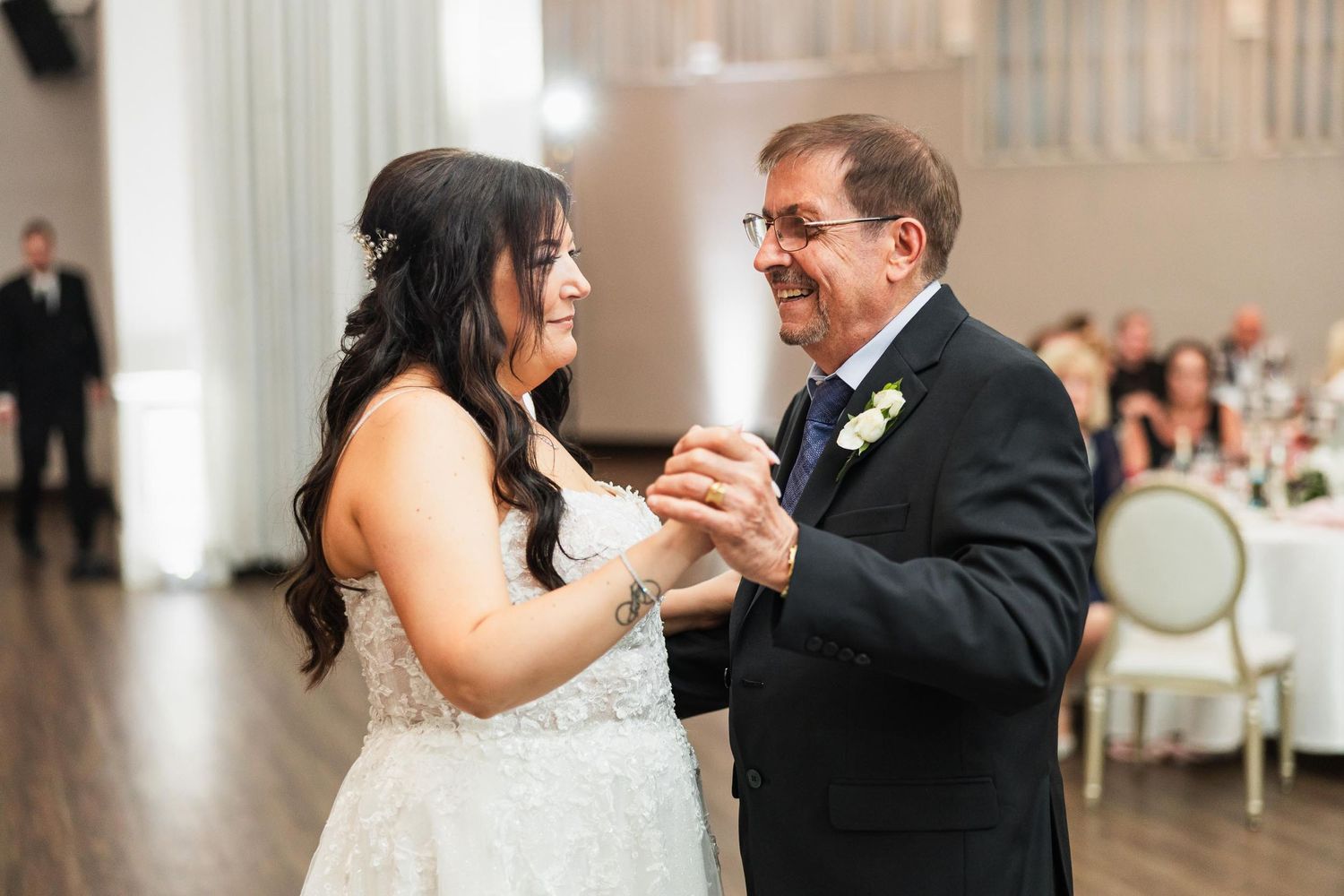 A tender dance moment at a wedding reception in an elegantly decorated venue with chandeliers.
