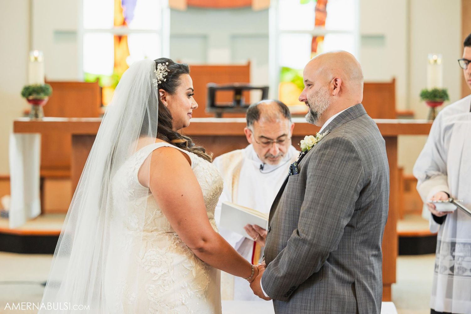 A wedding ceremony in progress with the couple and officiant at the altar.