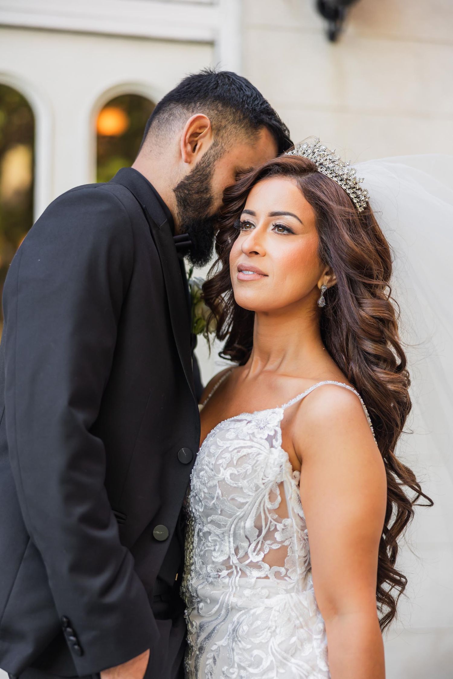 Romantic wedding moment captured in elegant outdoor setting.