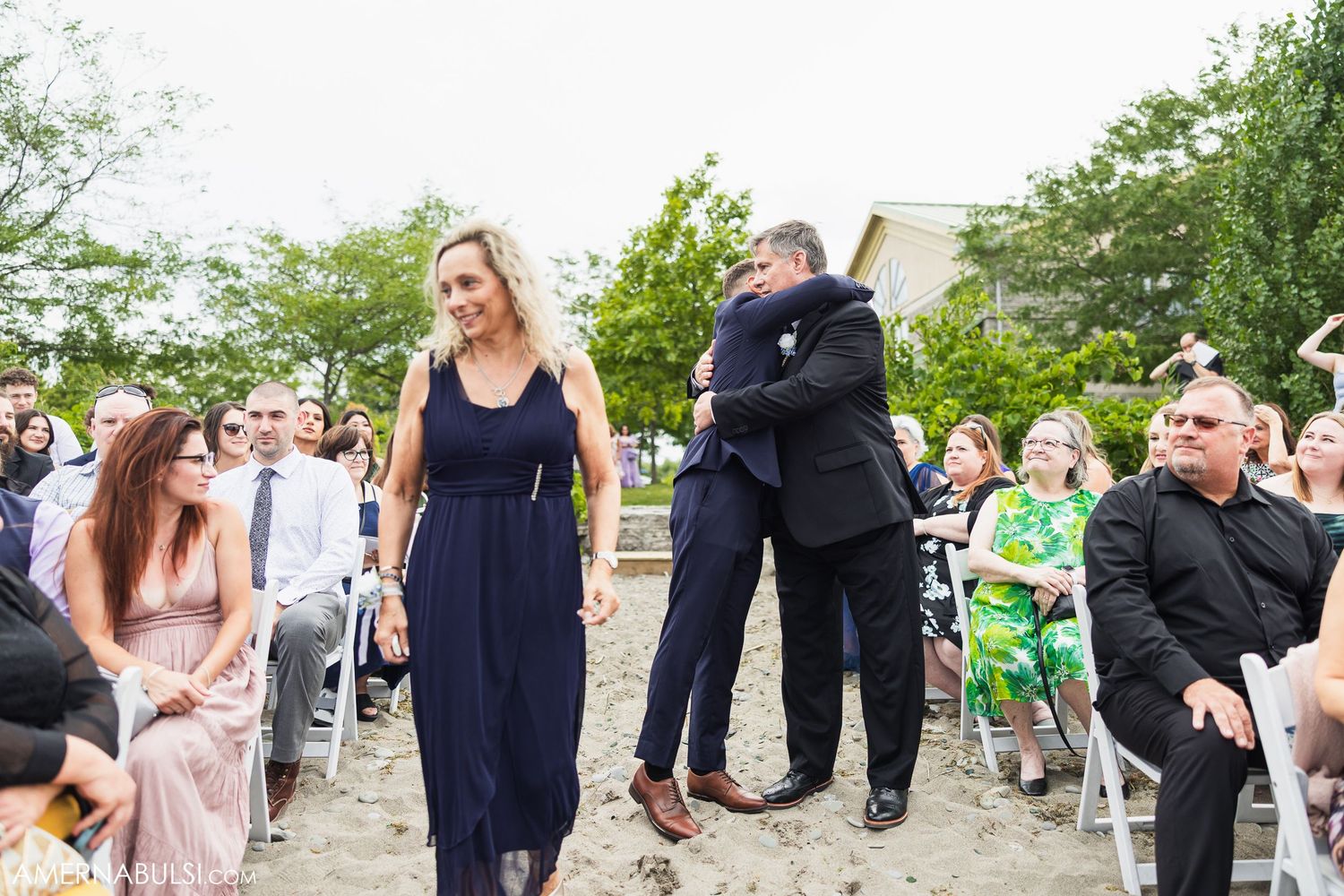 Wedding party members interact during outdoor celebrations in a garden setting.