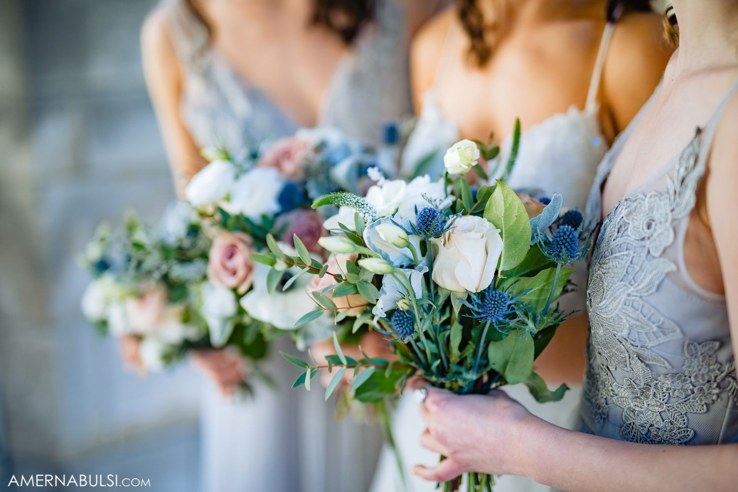Elegant wedding bouquets featuring blue and pink flowers with greenery.