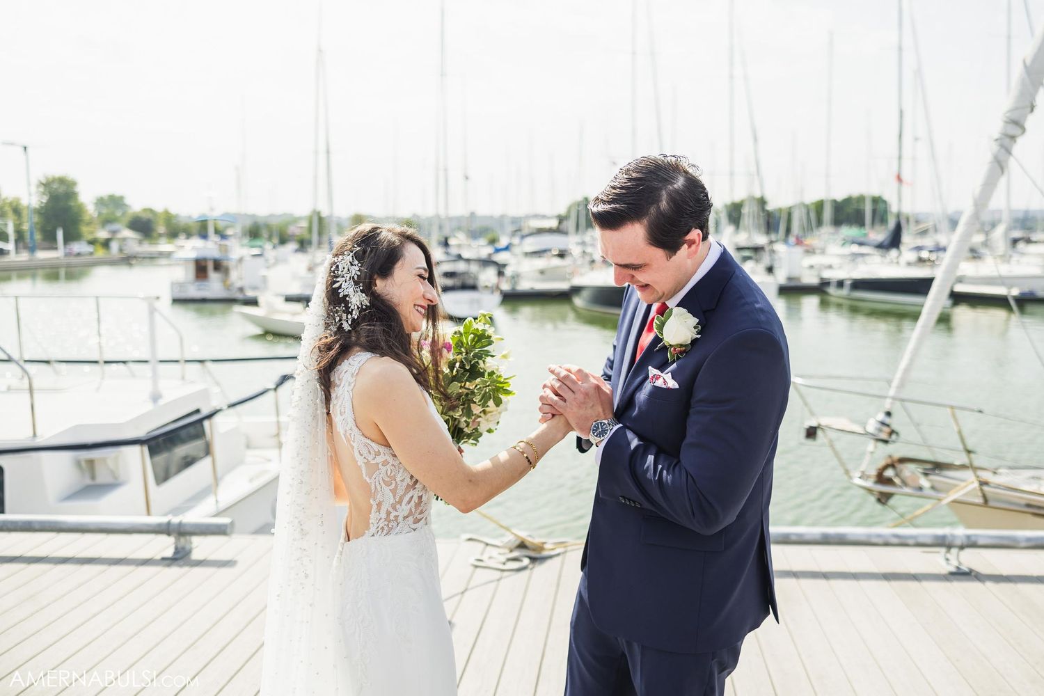 A joyful wedding moment captured on a dock with a marina backdrop.