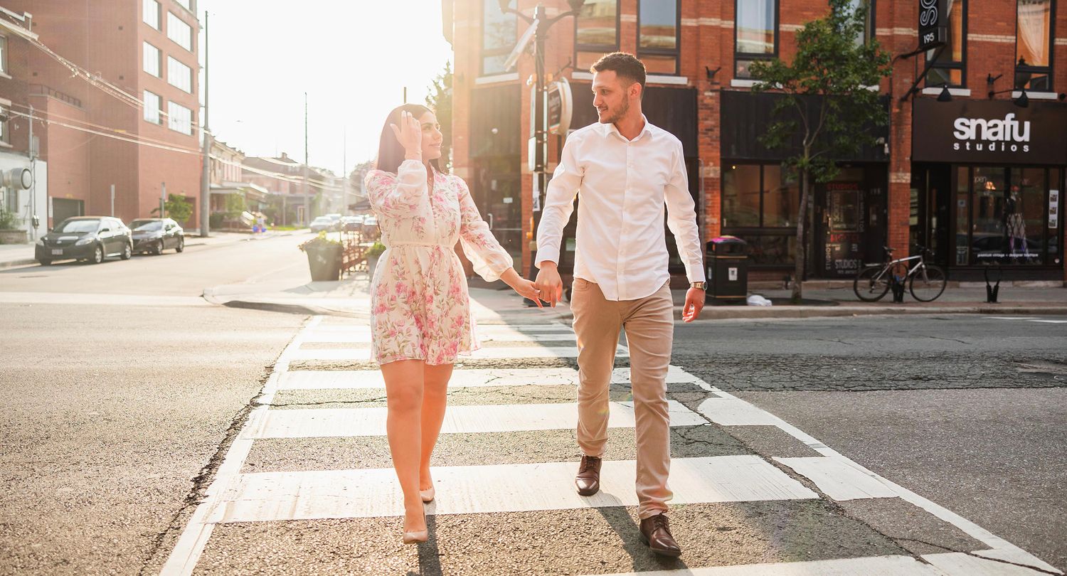 Urban engagement photoshoot on city sidewalk during golden hour.