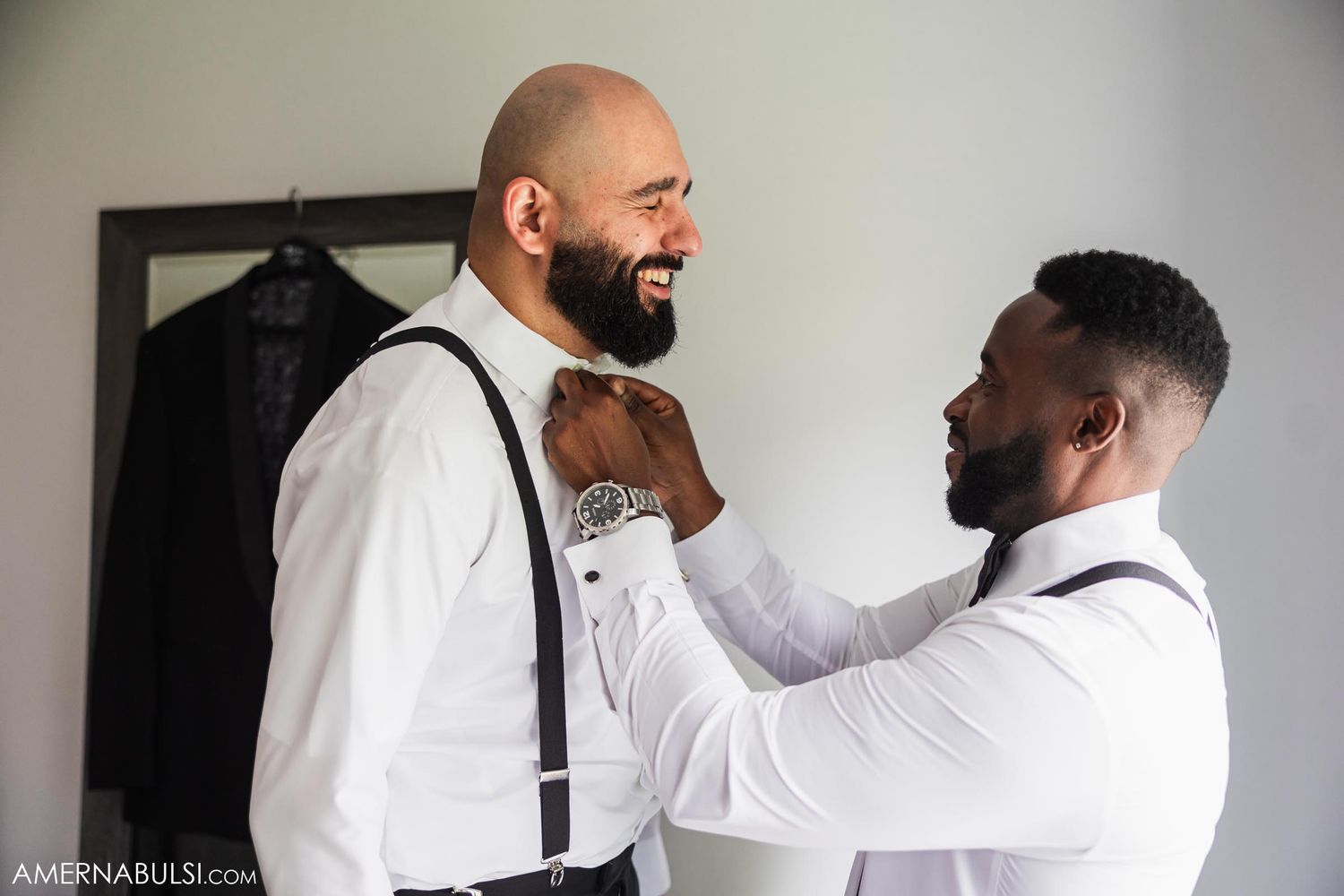 Two people adjusting formal wear and bow ties while getting dressed.
