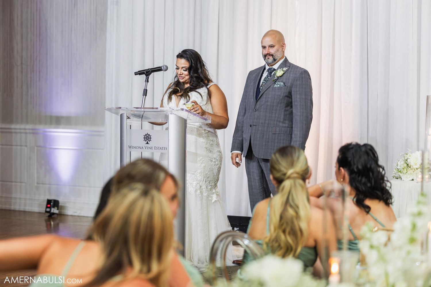 Couple giving wedding speeches at a podium during their reception.