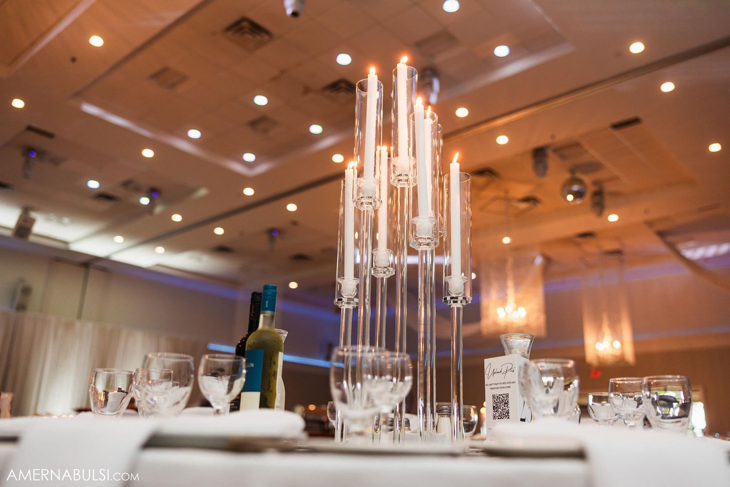 Modern crystal chandelier centerpiece on wedding reception table.