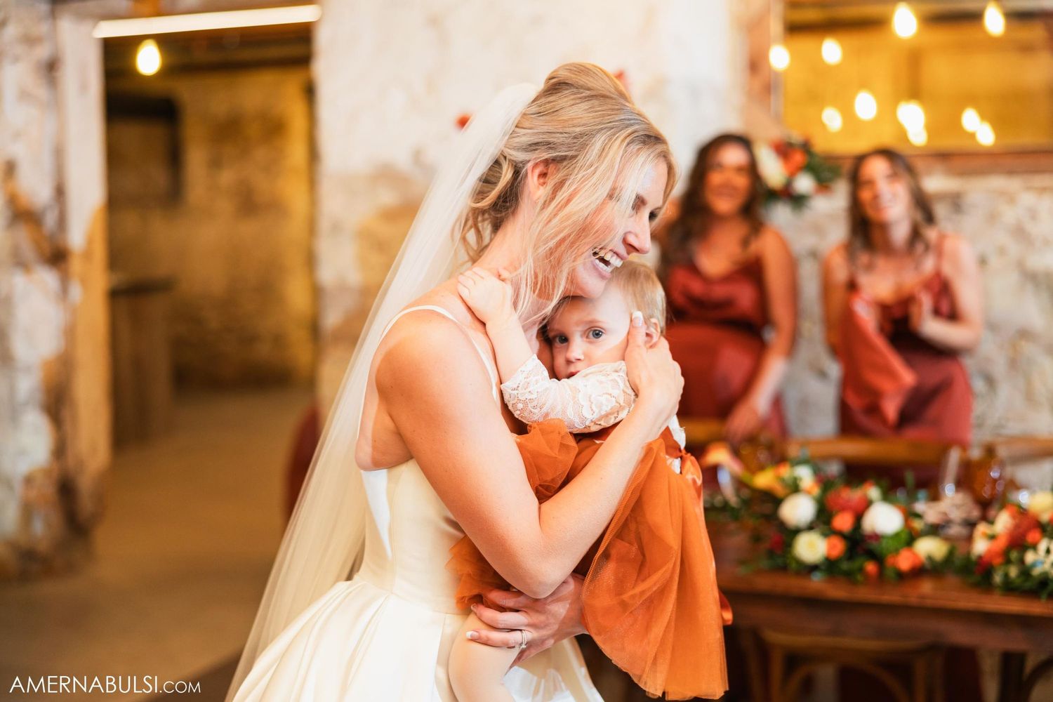 A bride in white dress shares an emotional moment during wedding celebrations.