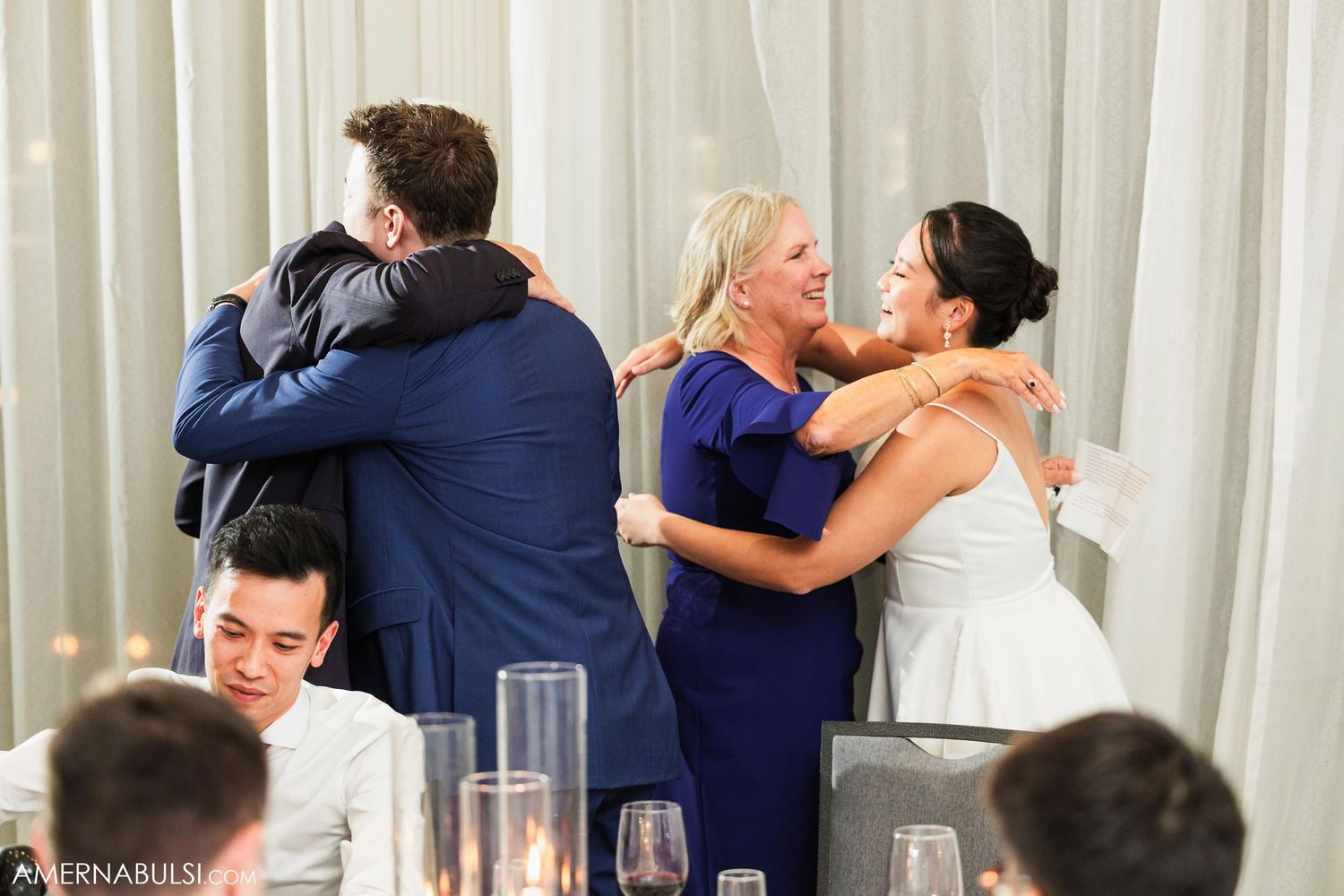 Emotional wedding reception hugs and embraces shared between family members.