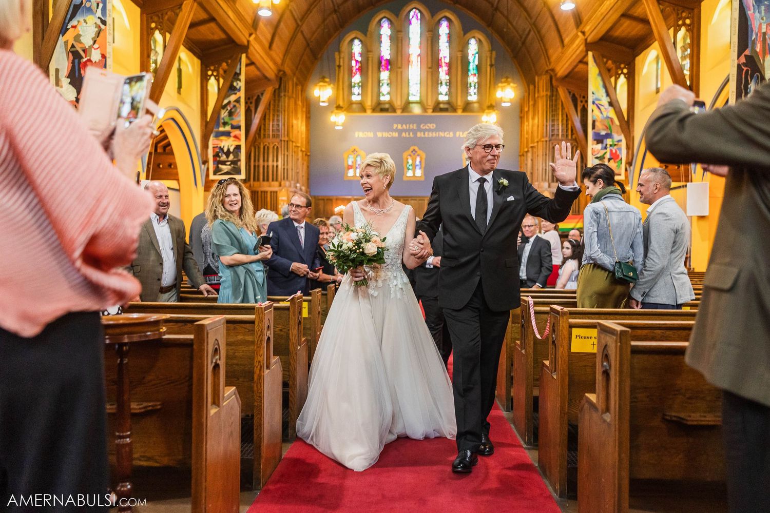 Newlyweds walk down the church aisle as guests celebrate their union.