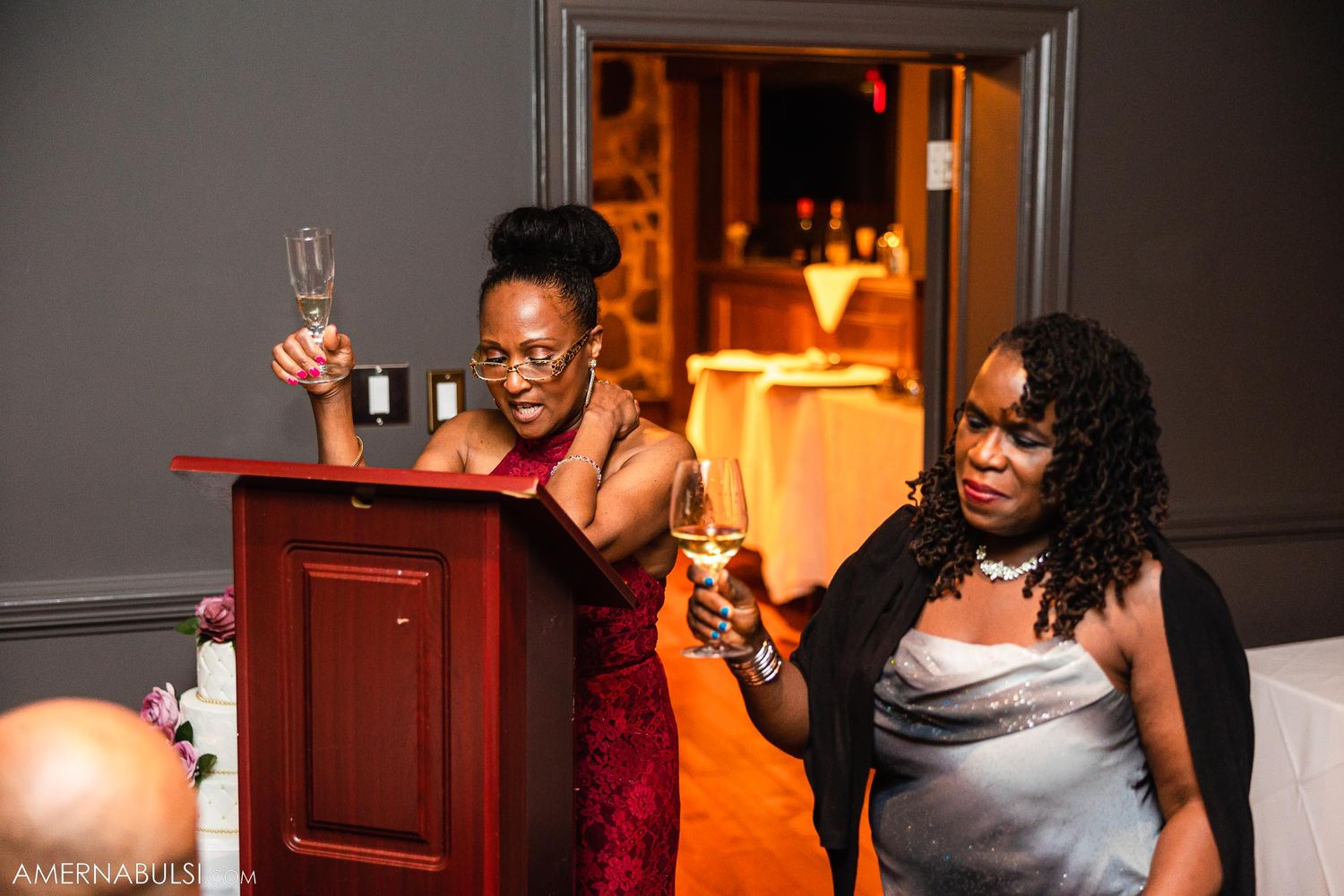 Wedding guests toasting with champagne glasses at an evening reception.