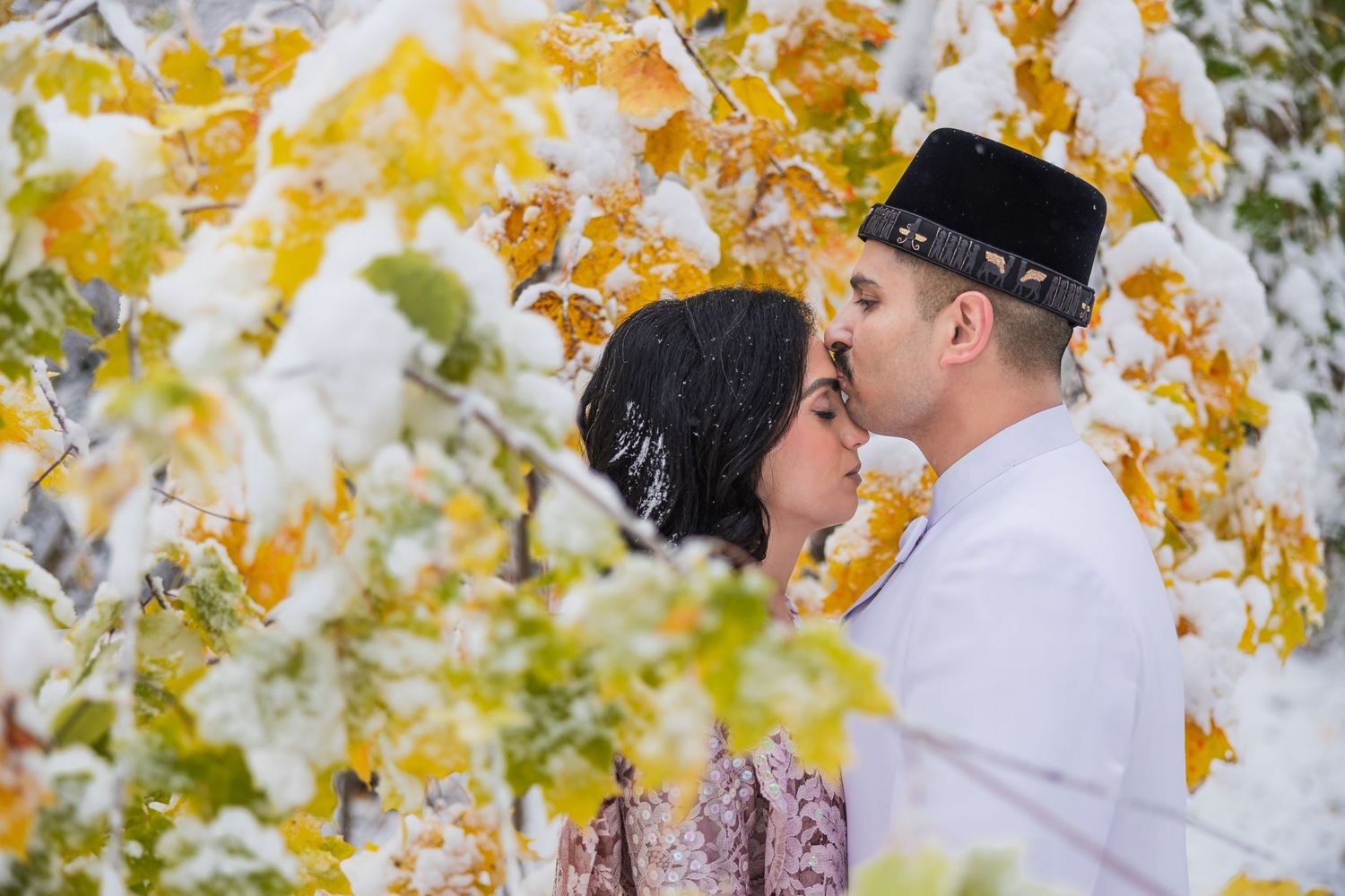 Autumn scene with yellow leaves framing a romantic moment against natural foliage.