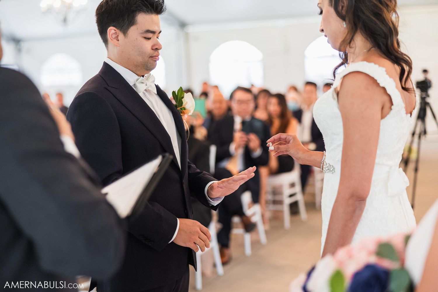 An intimate moment during wedding vows in a bright ceremony space.