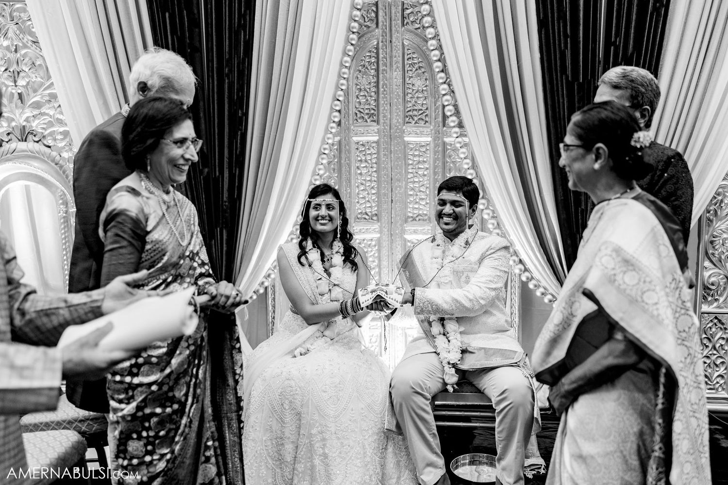Black and white photo captures intimate moment during traditional Indian wedding ceremony.