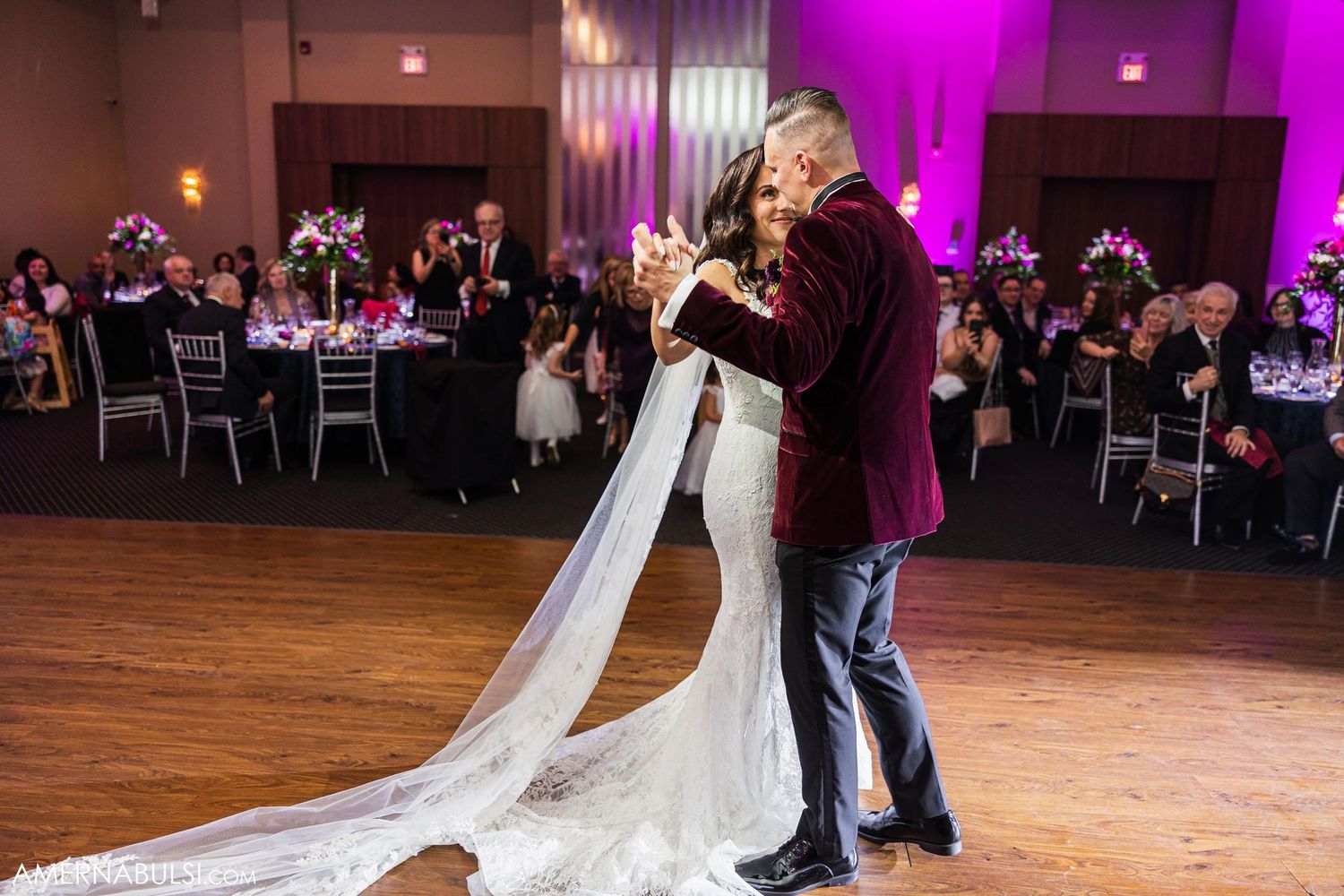 Wedding couple shares an intimate dance moment with flowing veil and atmospheric fog effects.