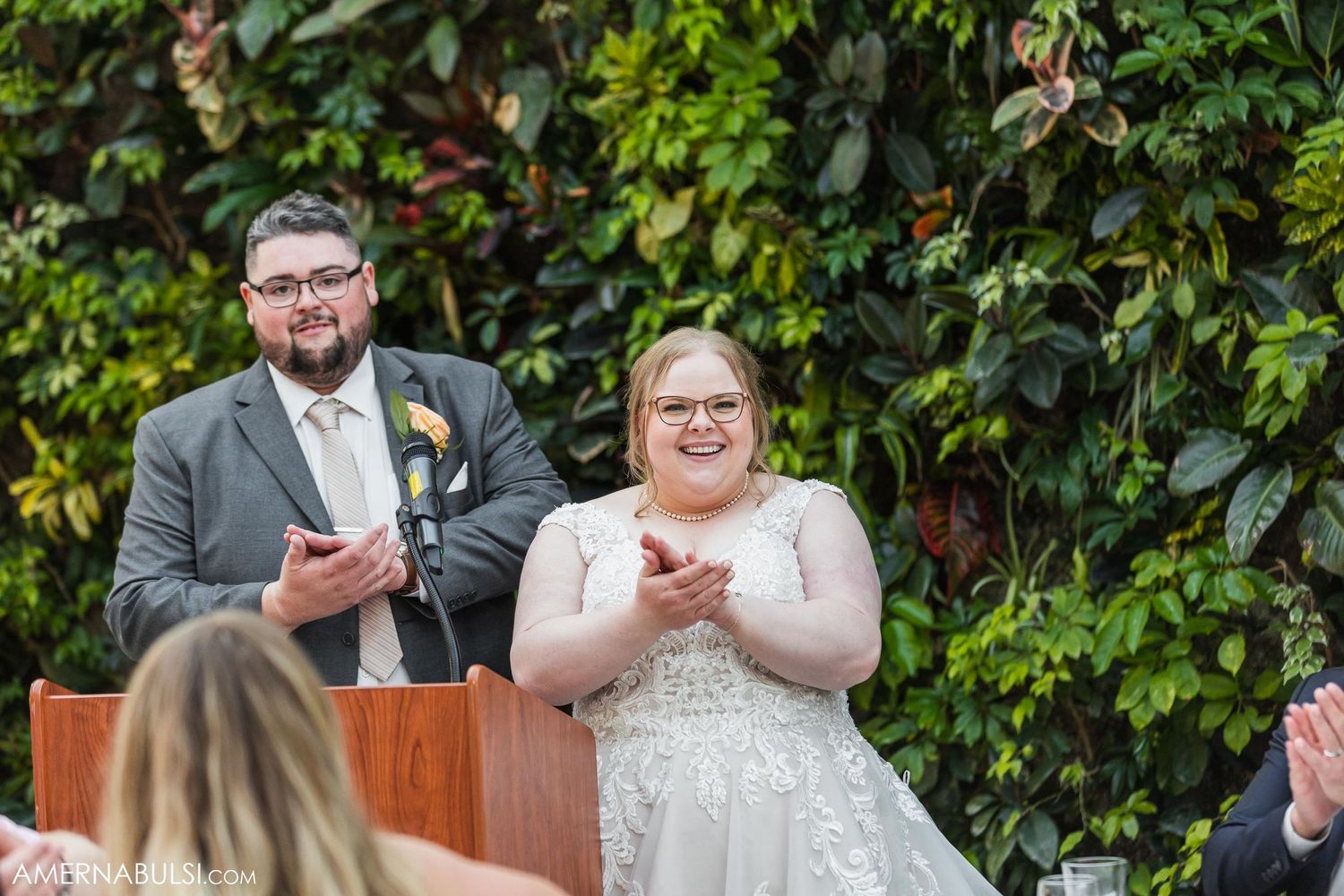 Couple sharing a fun moment while giving speeches at their wedding ceremony.