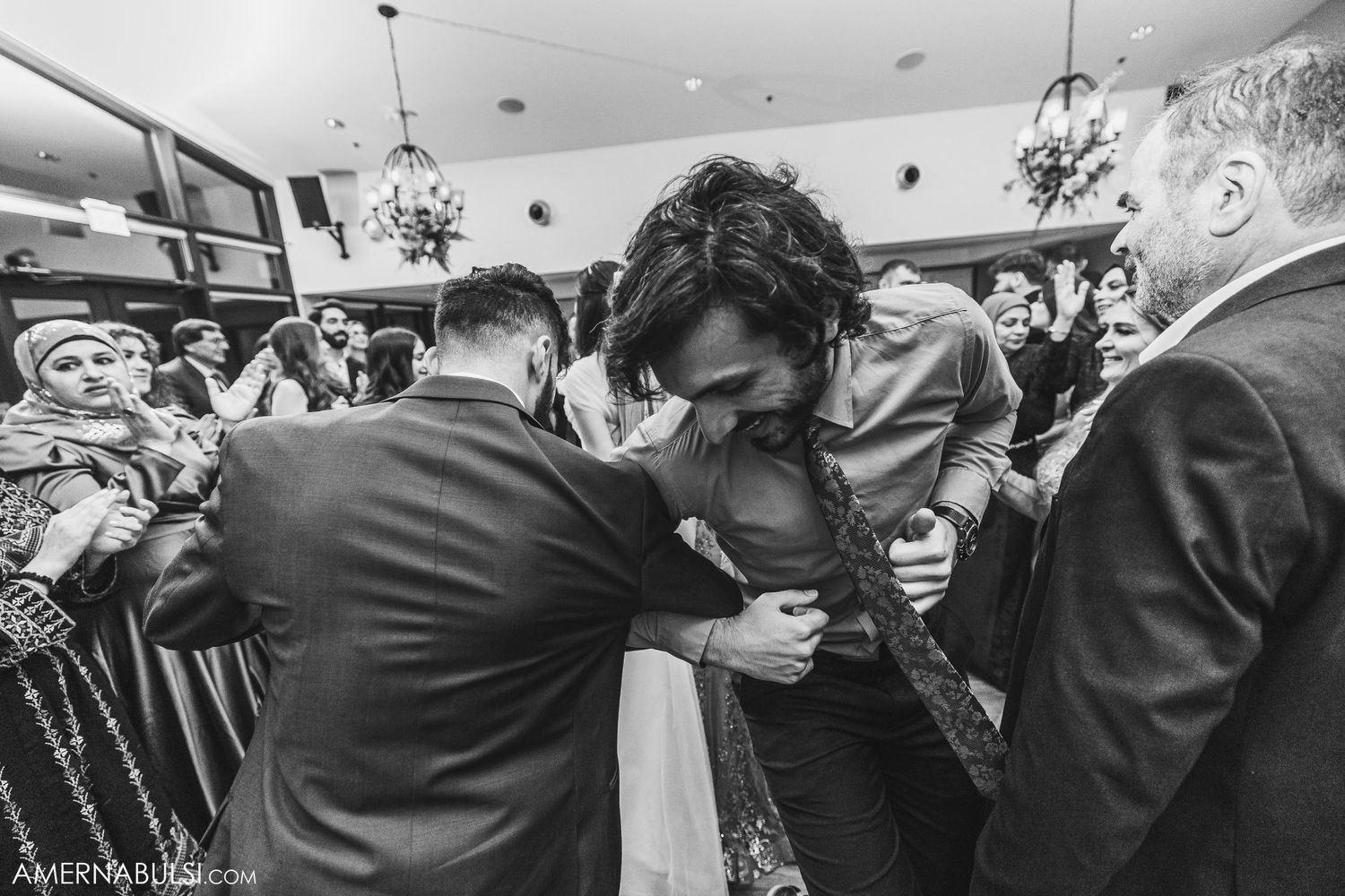 A tender moment captured during a celebratory gathering in a reception hall.