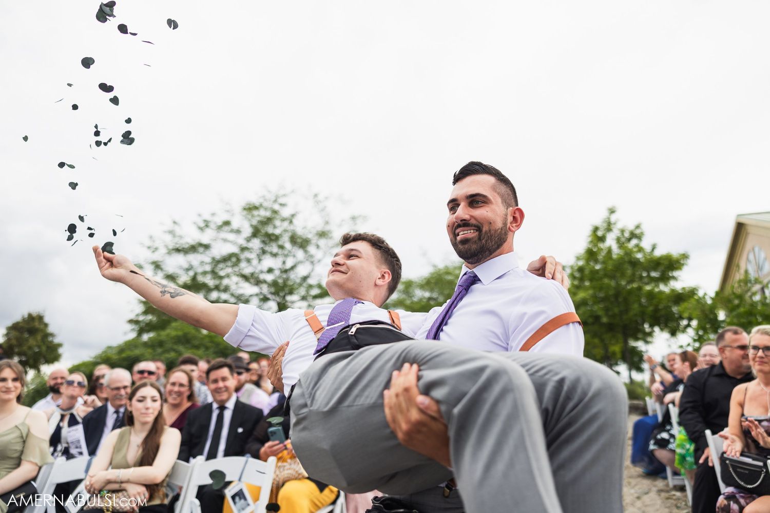 Wedding guests toss confetti during a joyous outdoor celebration.