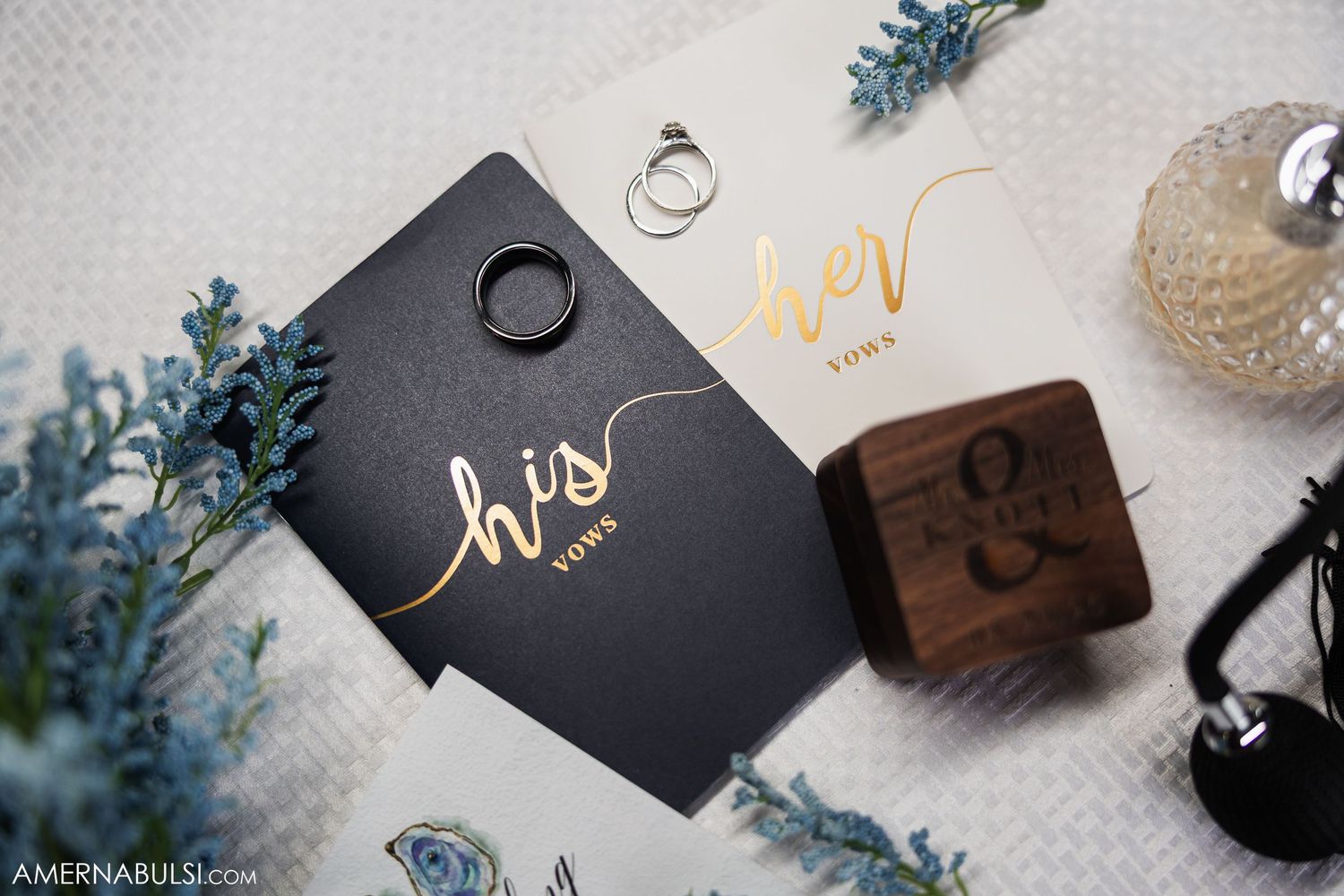 Wedding rings and stationery details with blue floral accents.