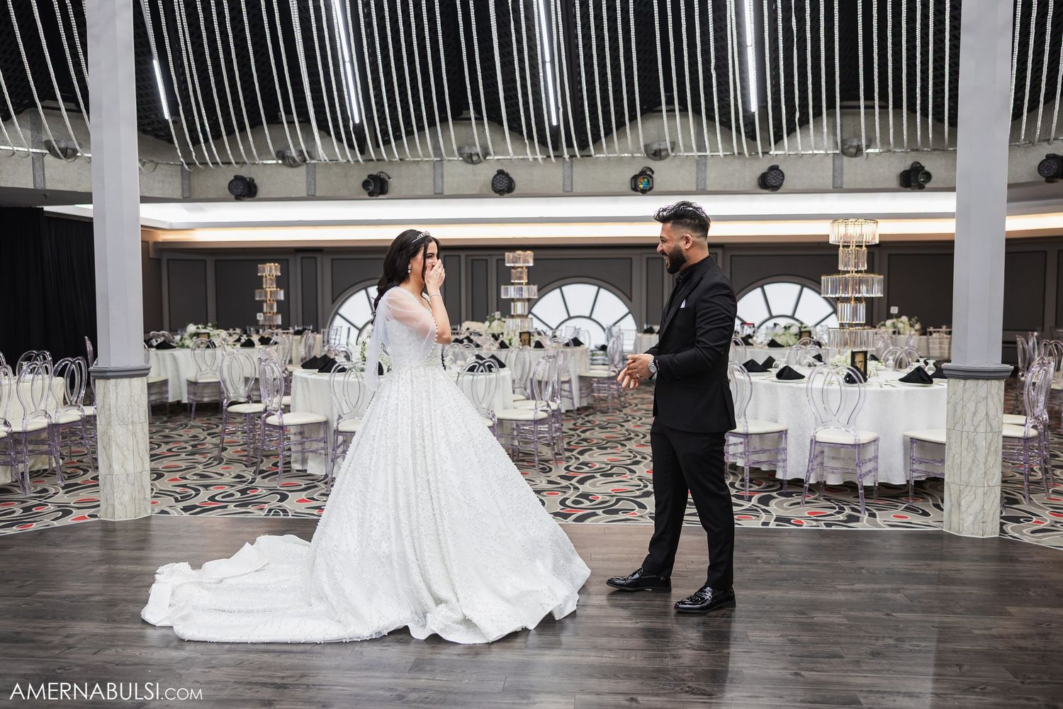 A couple in wedding attire shares a romantic moment on the dance floor during their reception celebration.