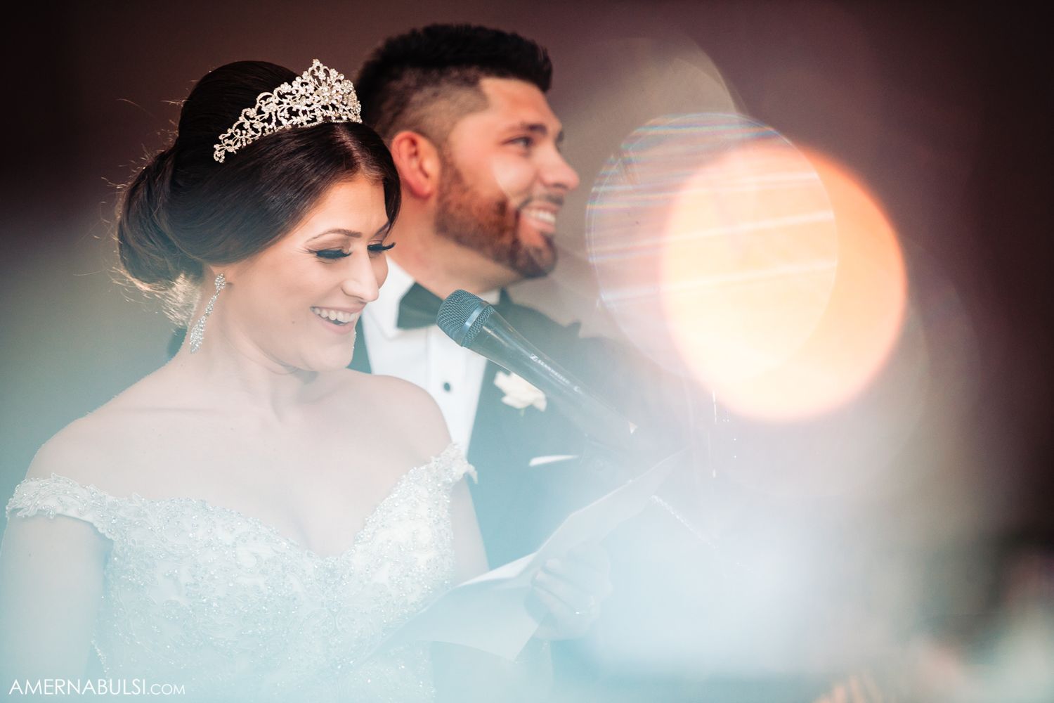 Romantic wedding couple shares an intimate dance moment under soft lighting at their reception.