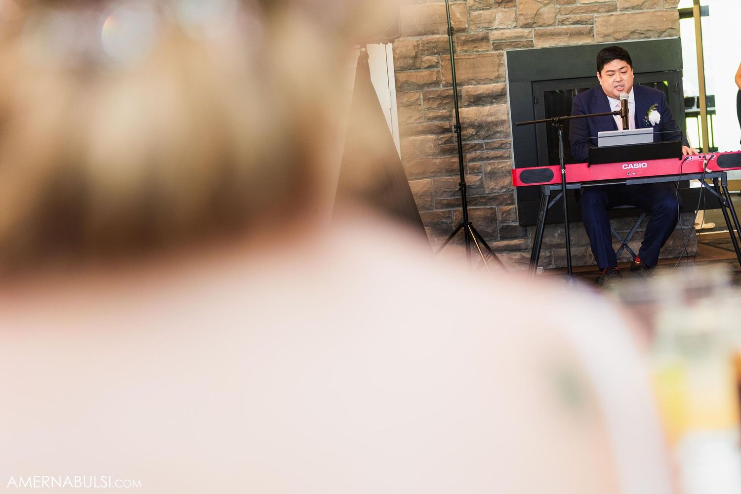 Guest speaking at wedding reception captured through creative framing.