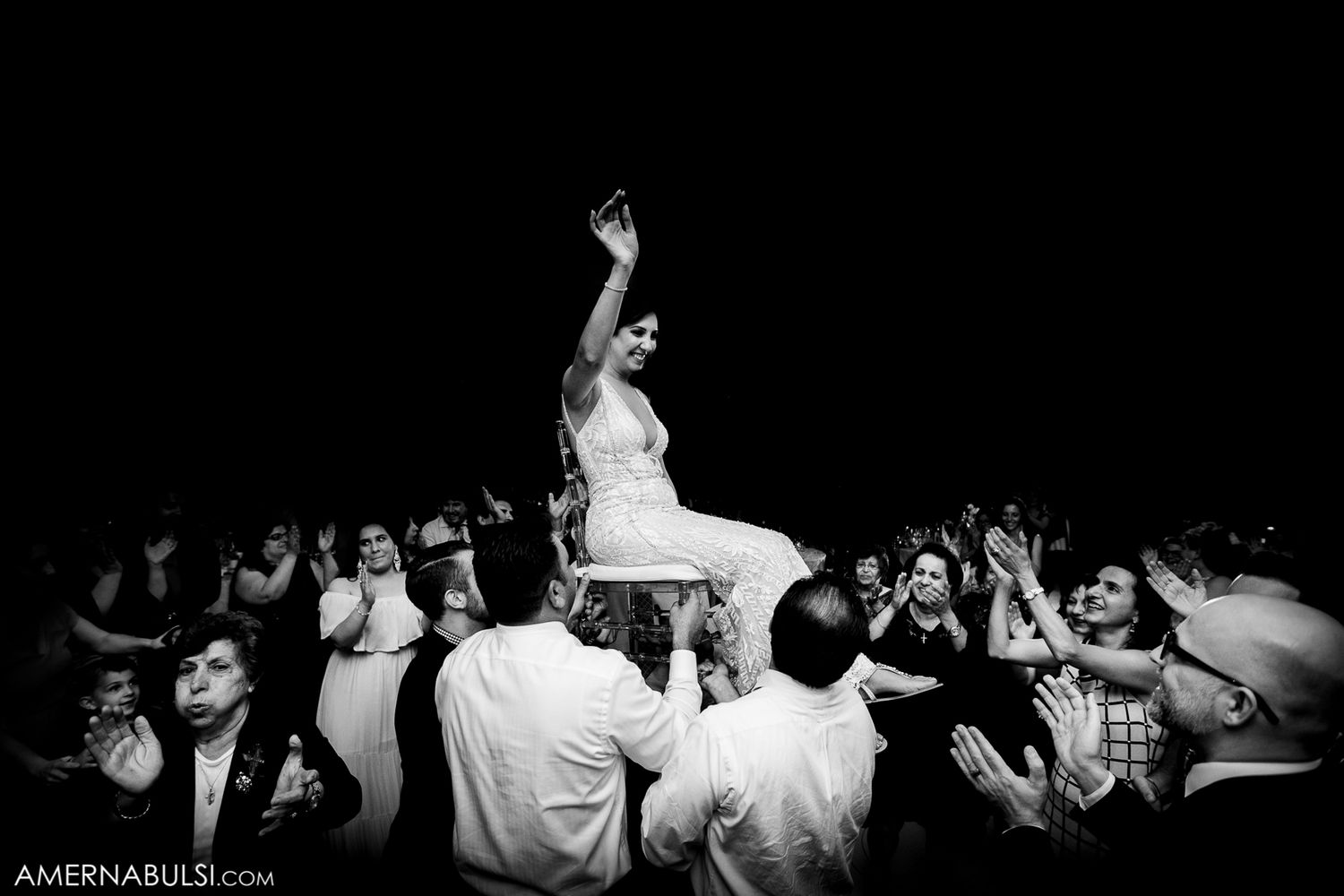 Dark silhouettes of party guests dancing and moving on a black background.
