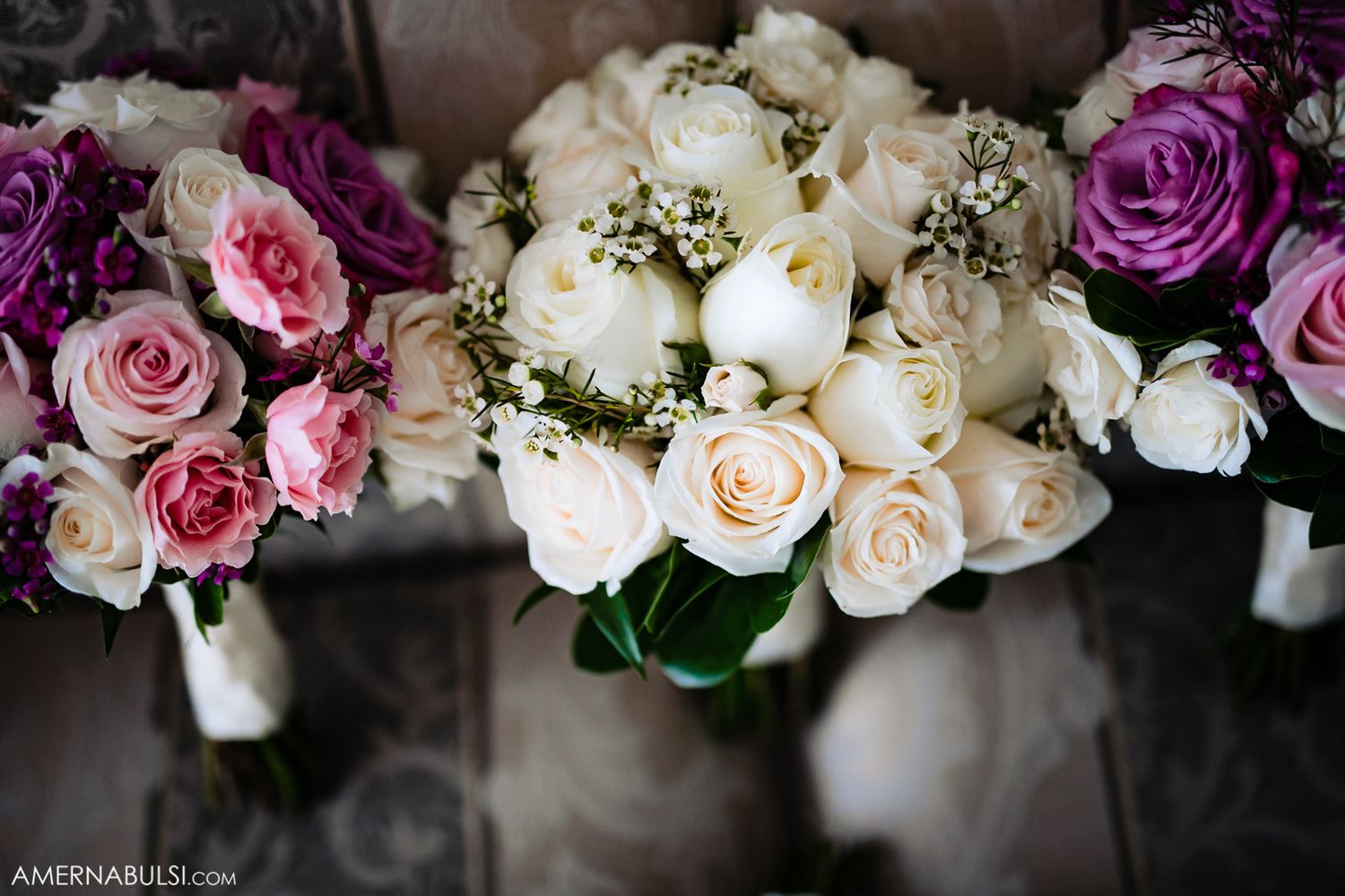 Beautiful arrangement of pink, purple, and white roses in a wedding bouquet.