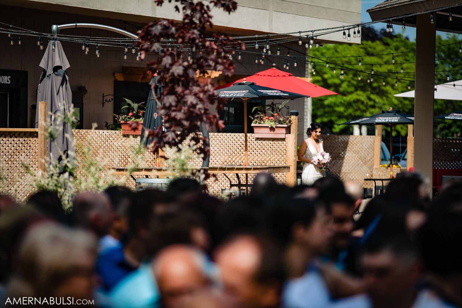 Outdoor wedding ceremony venue with natural lighting and rows of seated guests under trees.