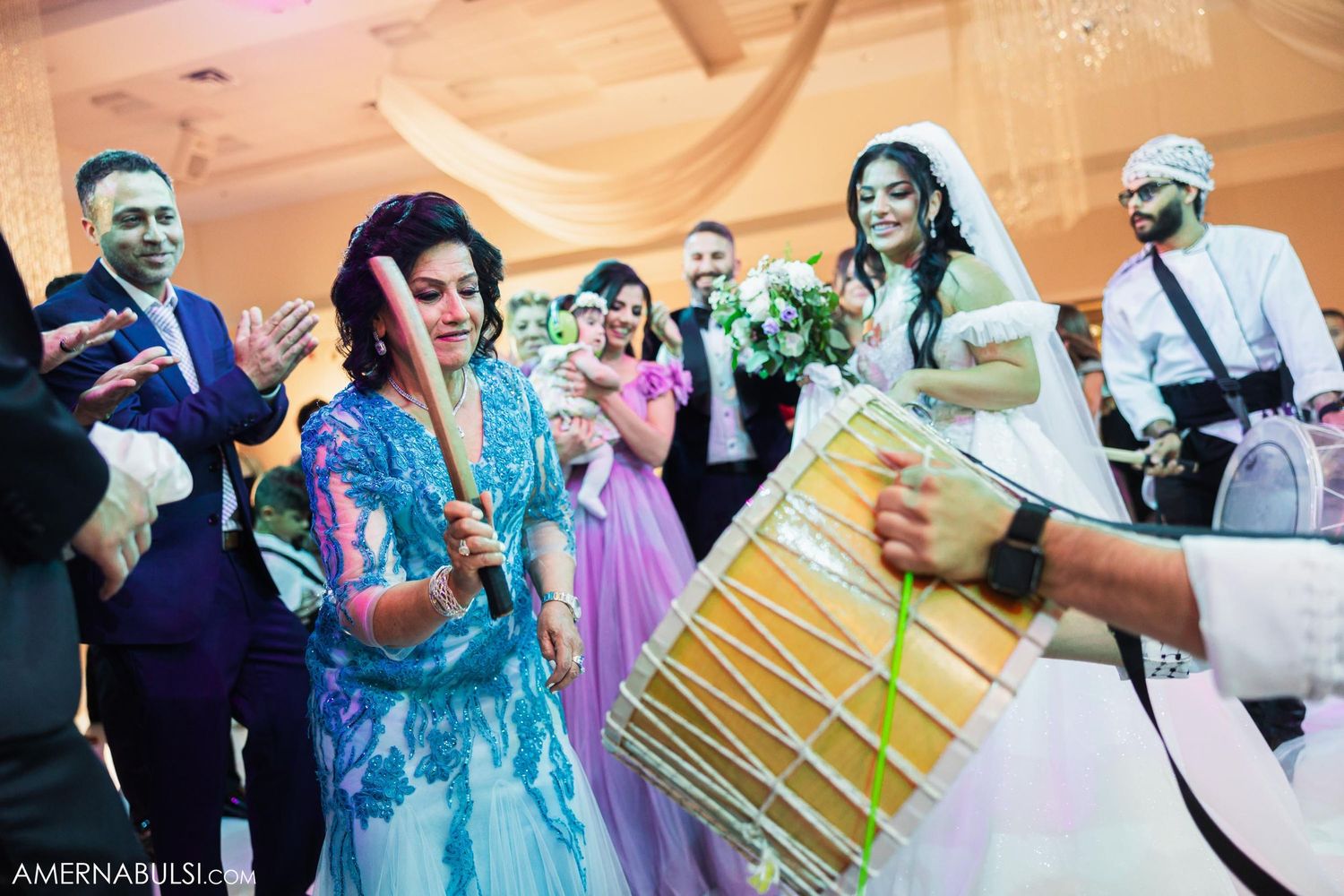Wedding celebration with traditional drummers and dancers in colorful attire.