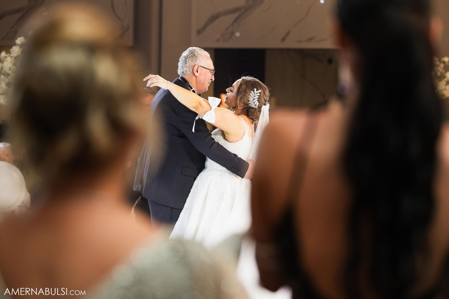 A tender father-daughter dance moment captured during a wedding reception.