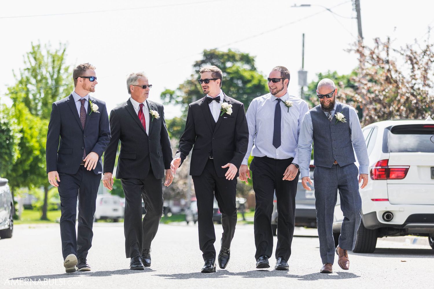 Group of groomsmen walking together on a sunny day before the ceremony.