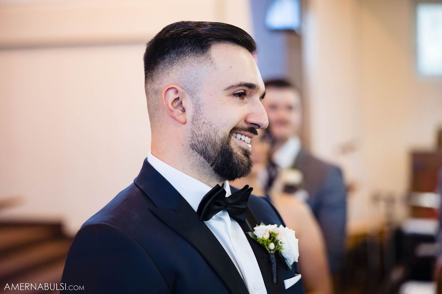Bride in lace gown walks down church aisle accompanied by father figure.
