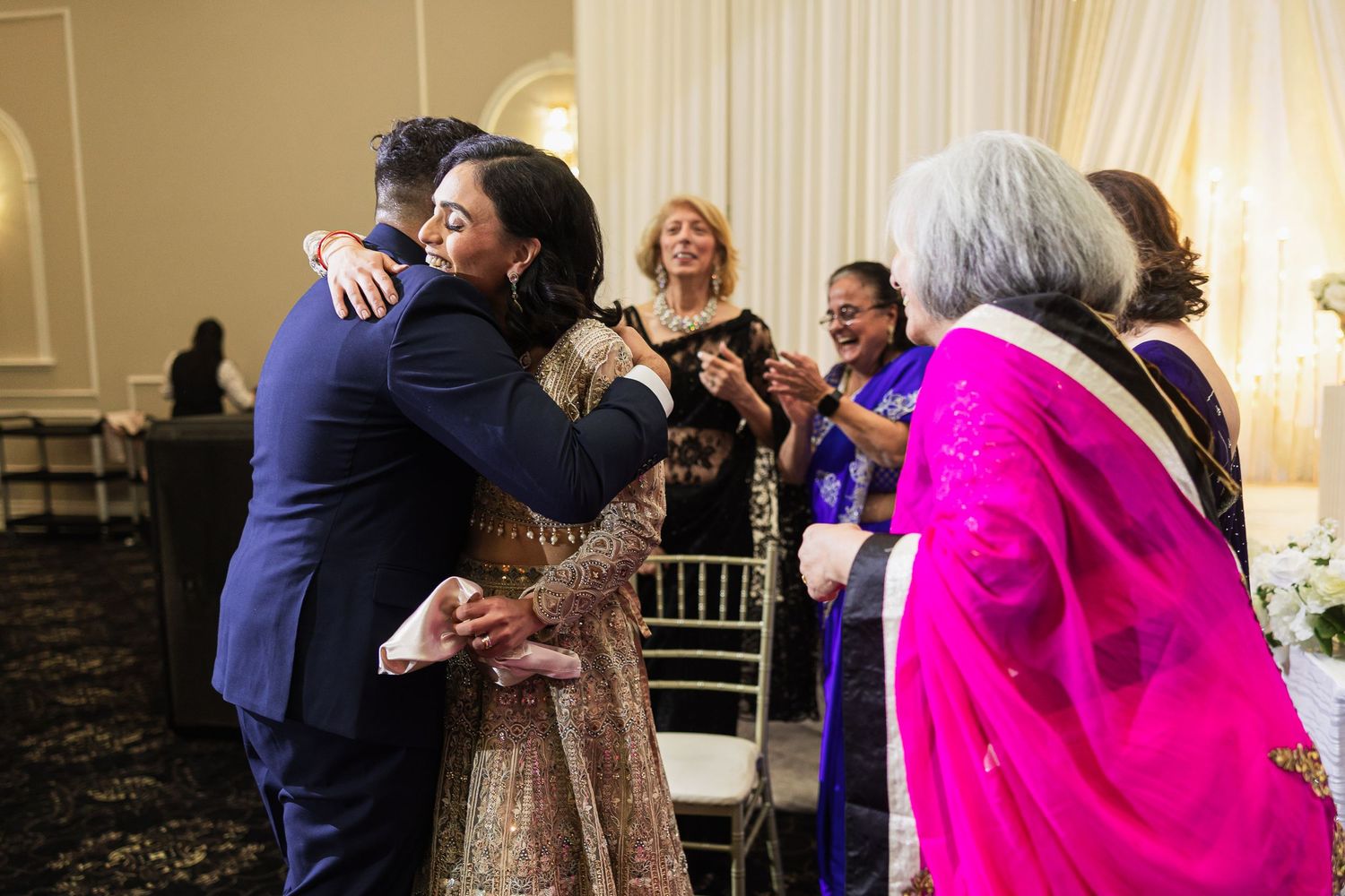 Wedding guests dancing and celebrating on the dance floor at an elegant reception venue.