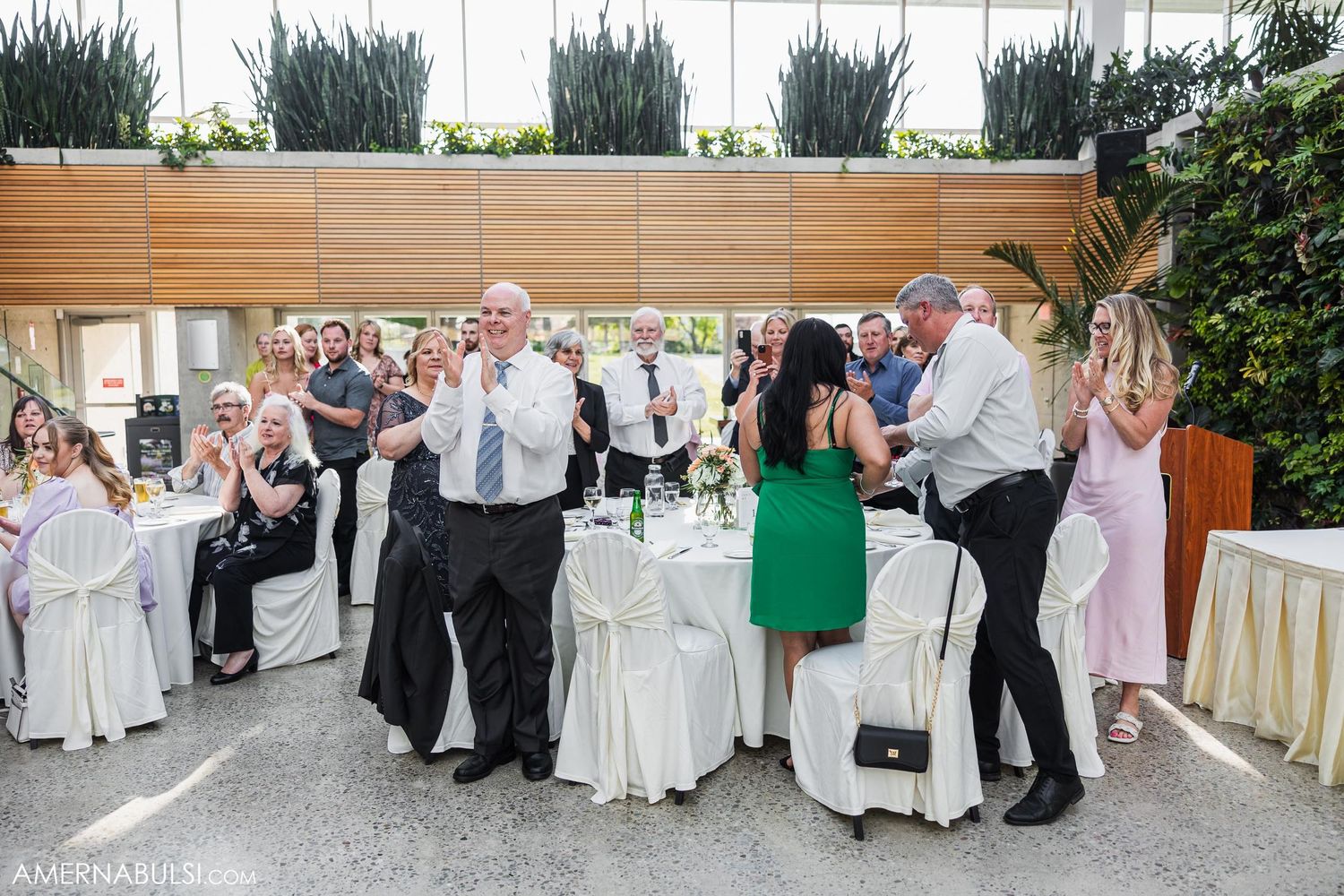 Wedding guests dancing and celebrating on the dance floor at a modern indoor venue.