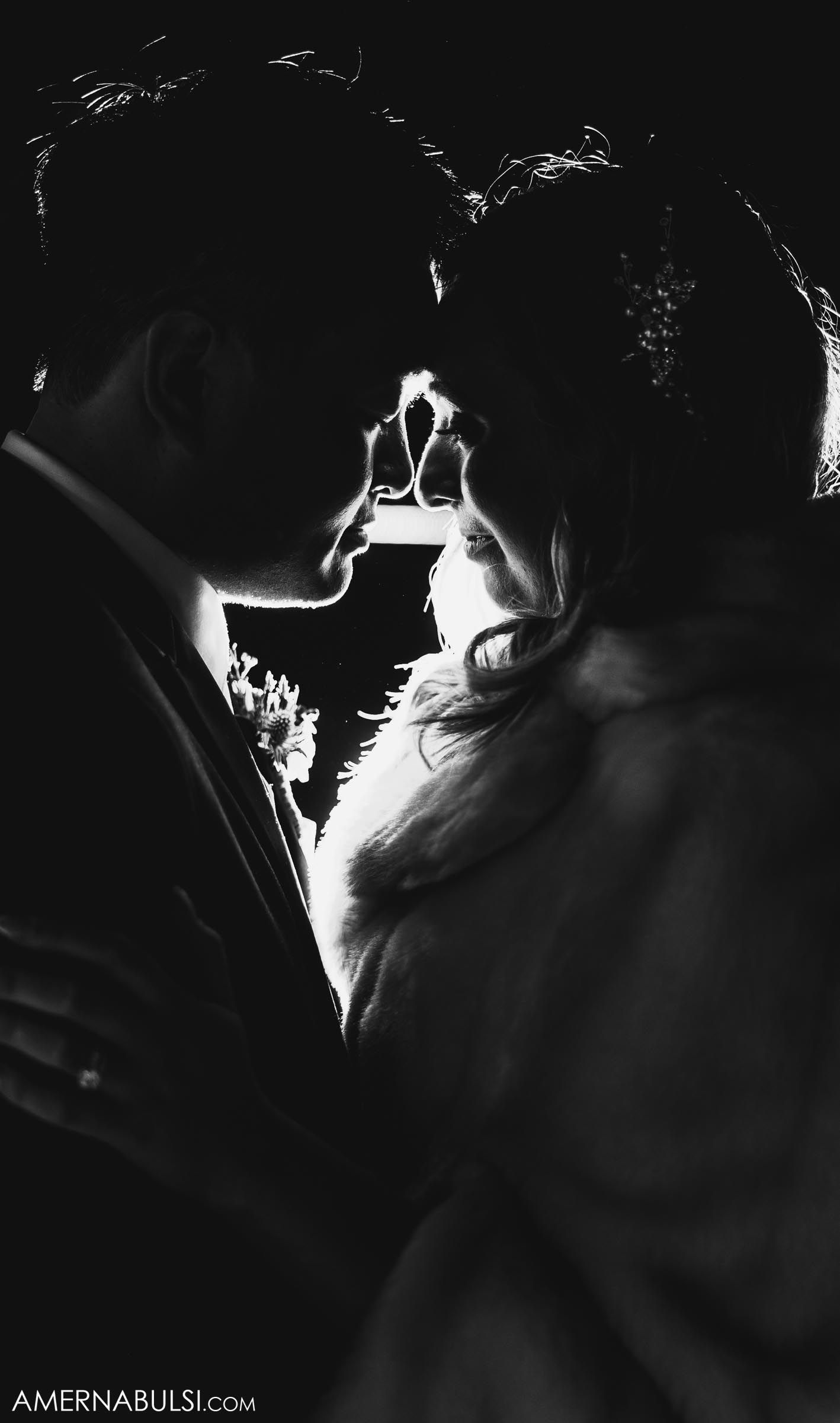 A dramatic black and white silhouette of a couple in an intimate moment.