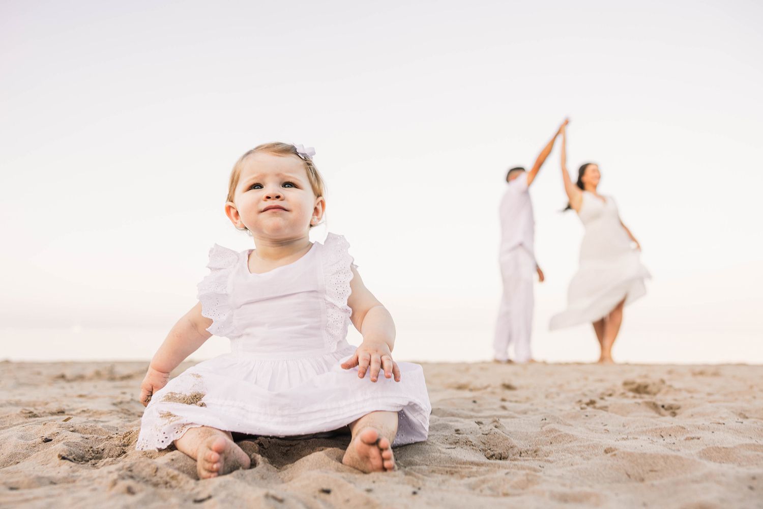 Series of shots showing a small child playing on a bright sandy beach.