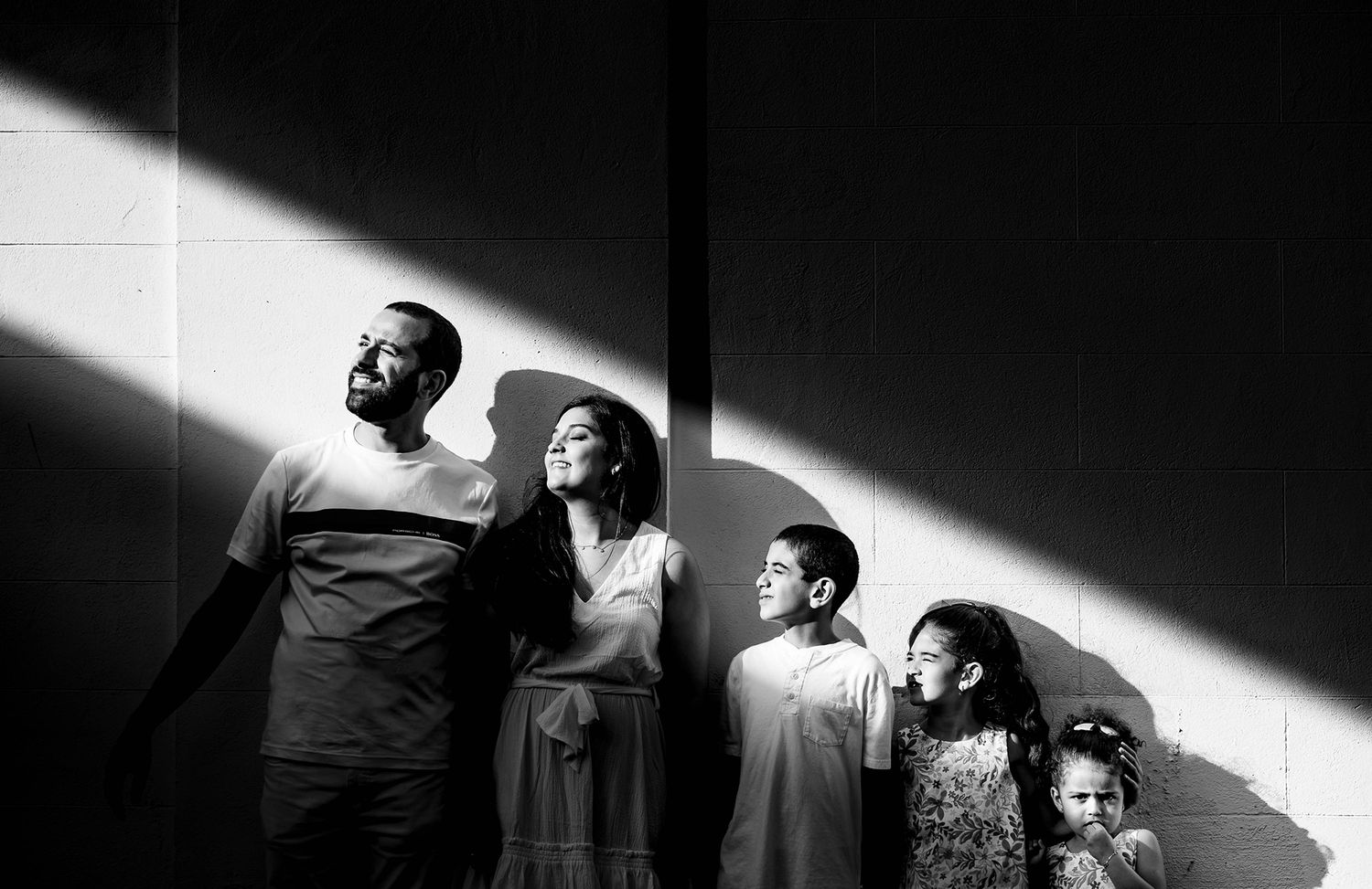 Dramatic black and white photographs showing angular shadows and contrasting light patterns.