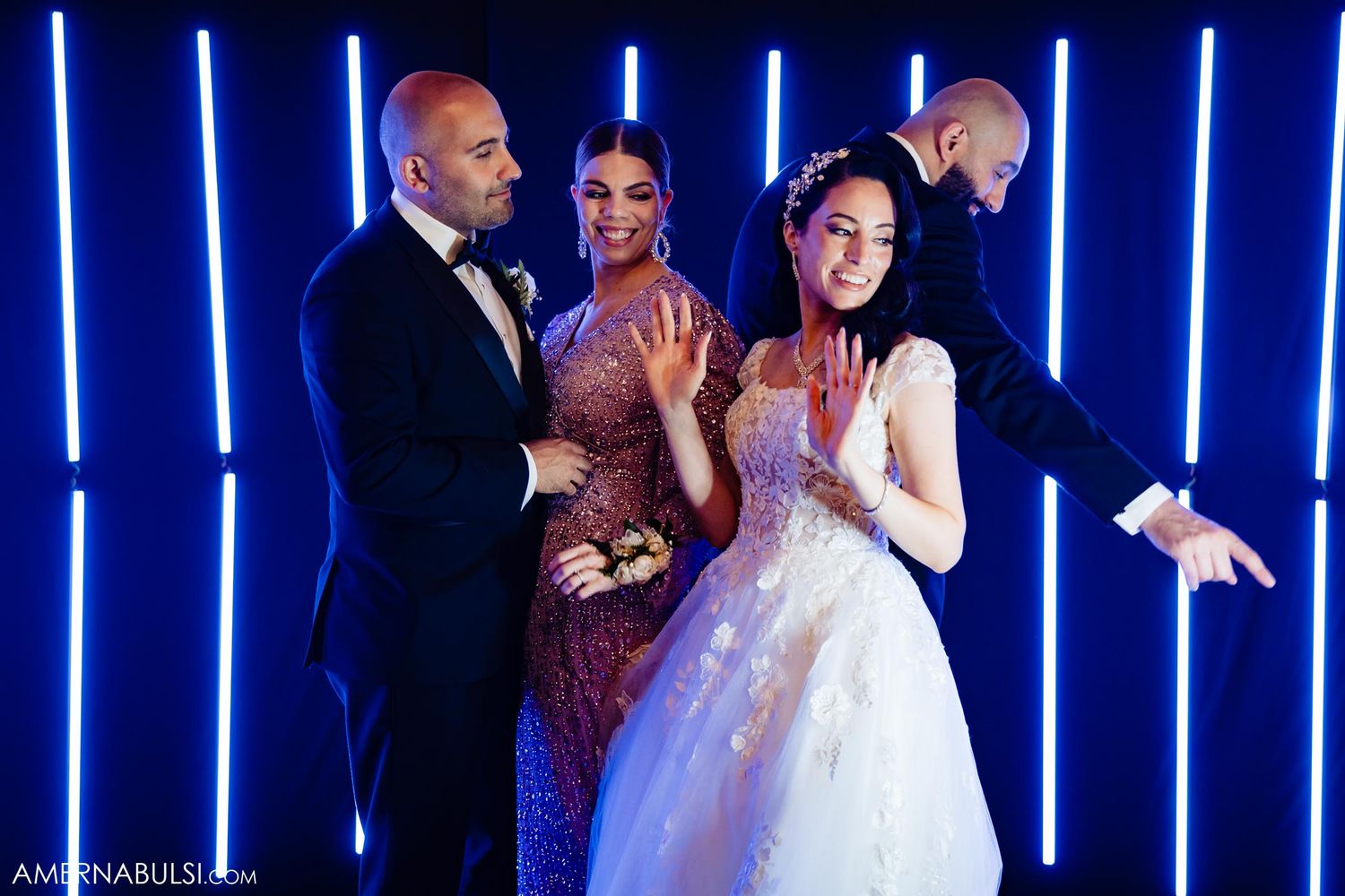 Wedding celebration with blue neon lights as guests dance and celebrate in formal attire.