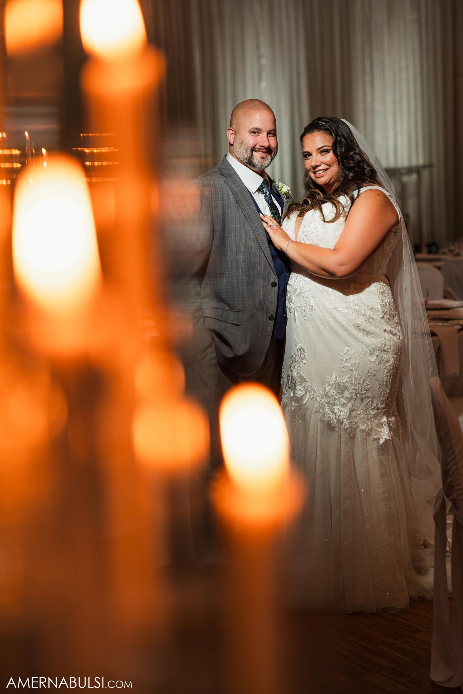 Romantic candlelit portrait of newlyweds in wedding attire.