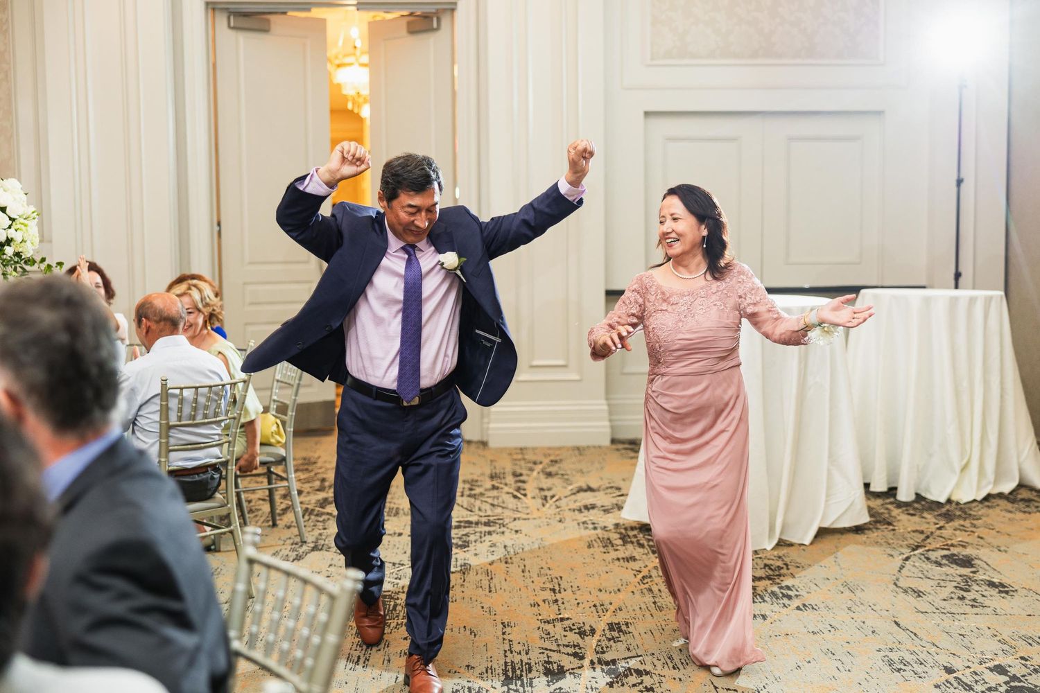 Wedding guests celebrate with enthusiastic dancing at reception.