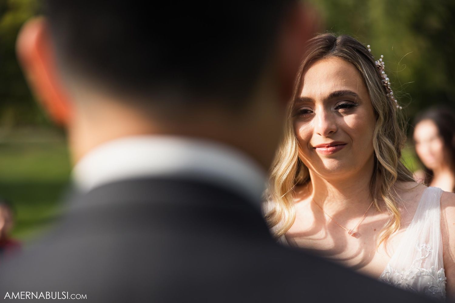 Close-up shot of a bride during an outdoor wedding ceremony with soft natural lighting.