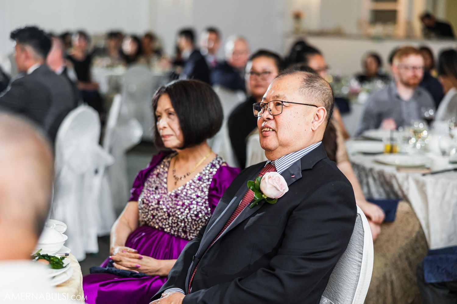 Wedding guests enjoying the reception while seated at decorated tables.