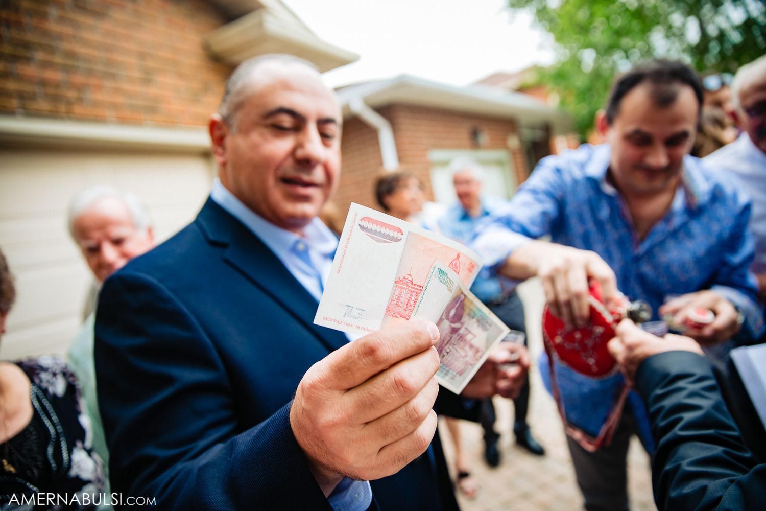 A series of hands exchanging money and documents in a business transaction setting outdoors.