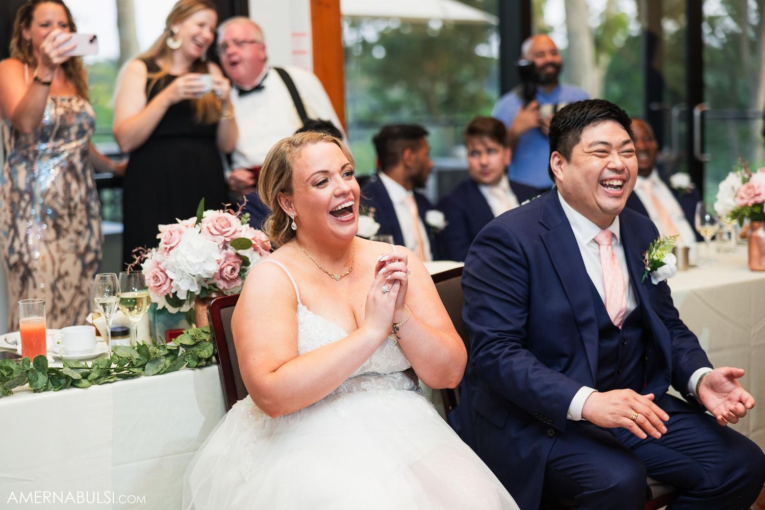 Wedding couple reacts with joy during reception celebration.
