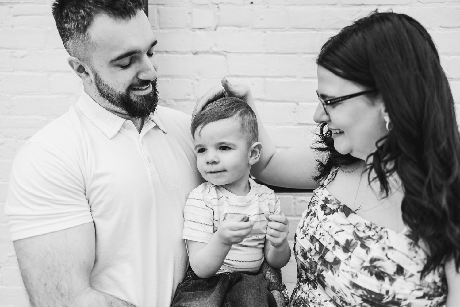 Close-up candid black and white portrait of family sharing tender moment.