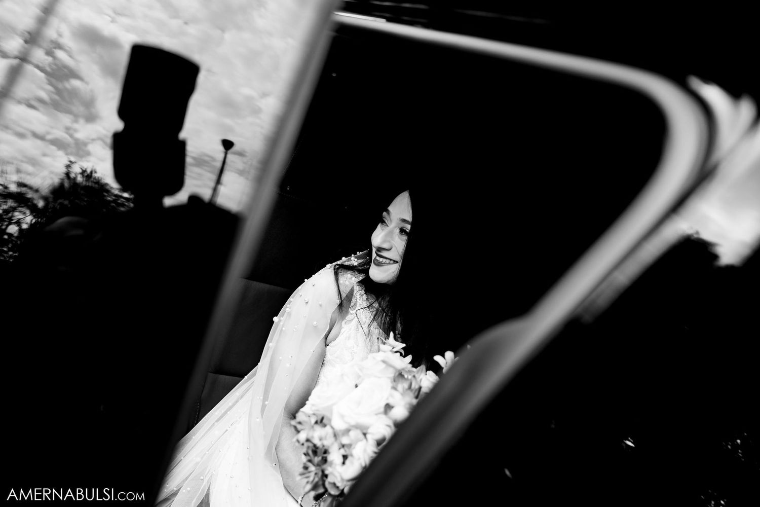 Artistic black and white reflection of bride in car window.