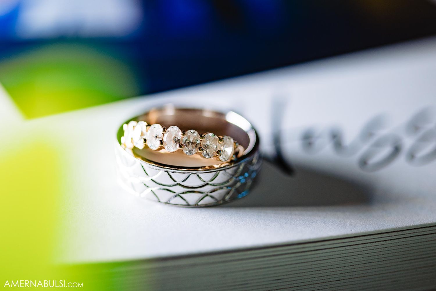 Close-up of an elegant rose gold wedding ring with diamond details on a textured surface.