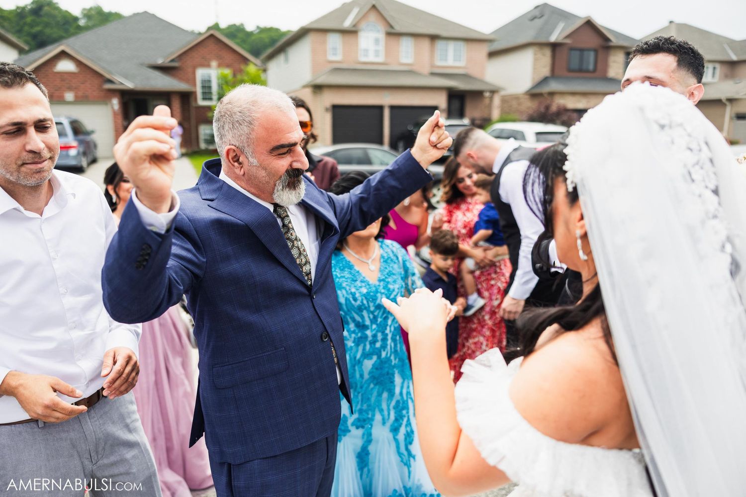 Wedding guests celebrate enthusiastically during outdoor suburban celebration.