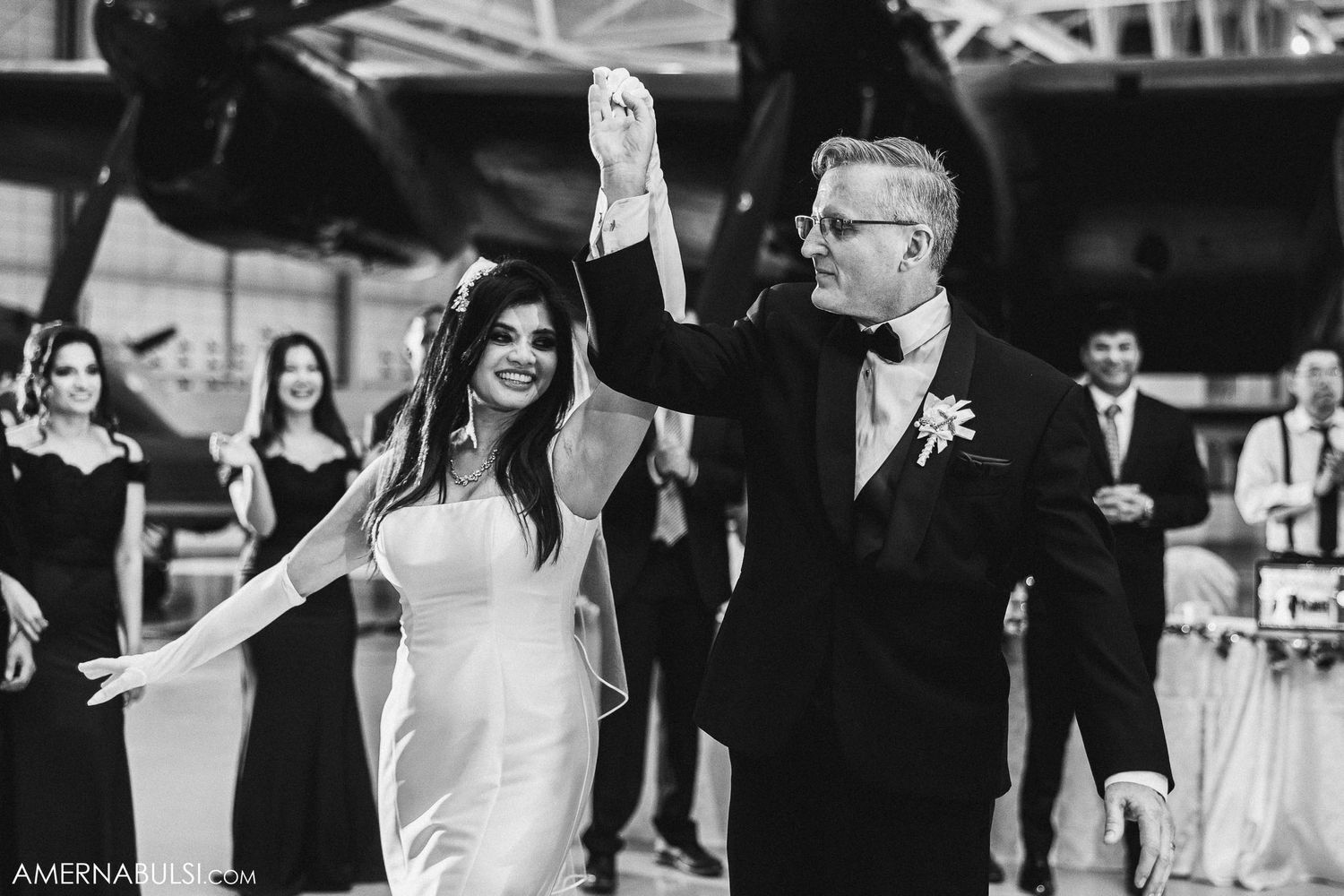 A black and white photo of a couple dancing together at their wedding reception.